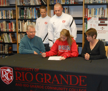 Dixie Heights High's Ashley Meek signs with Rio Grande women's soccer as her parents and RedStorm coaches look on